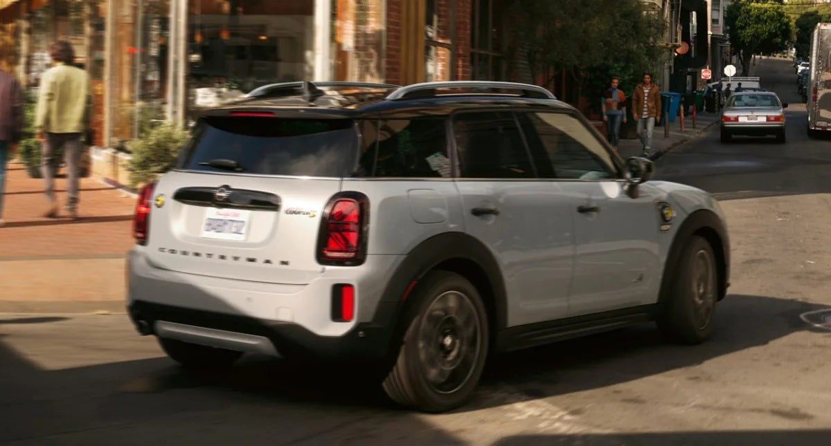 The MINI Cooper SE Countryman PHEV turning a corner in the city. Tom Bush MINI in Jacksonville FL