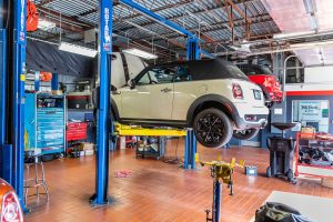 White MINI on lift at service center